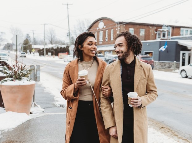 A picture of a couple walking down the street holding hands while visiting local holiday events.