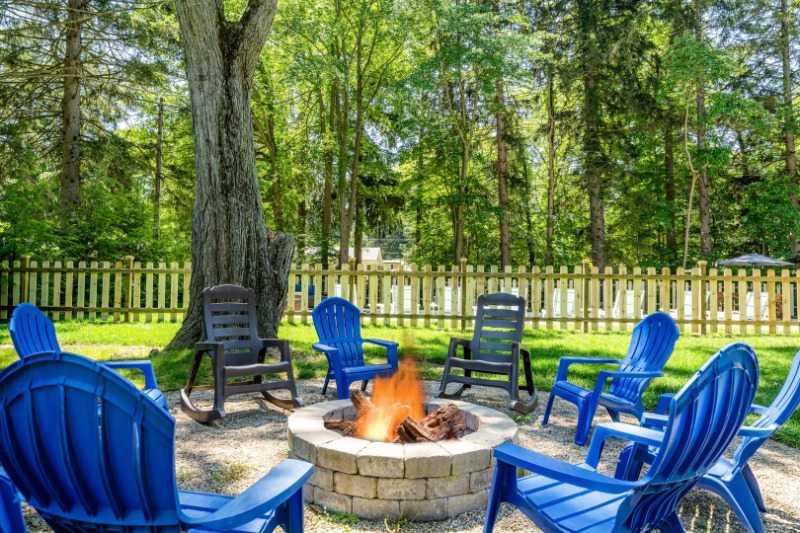 A firepit with several chairs situated around it at A Wheel Tree Cottage vacation rental in Sawyer, MI.