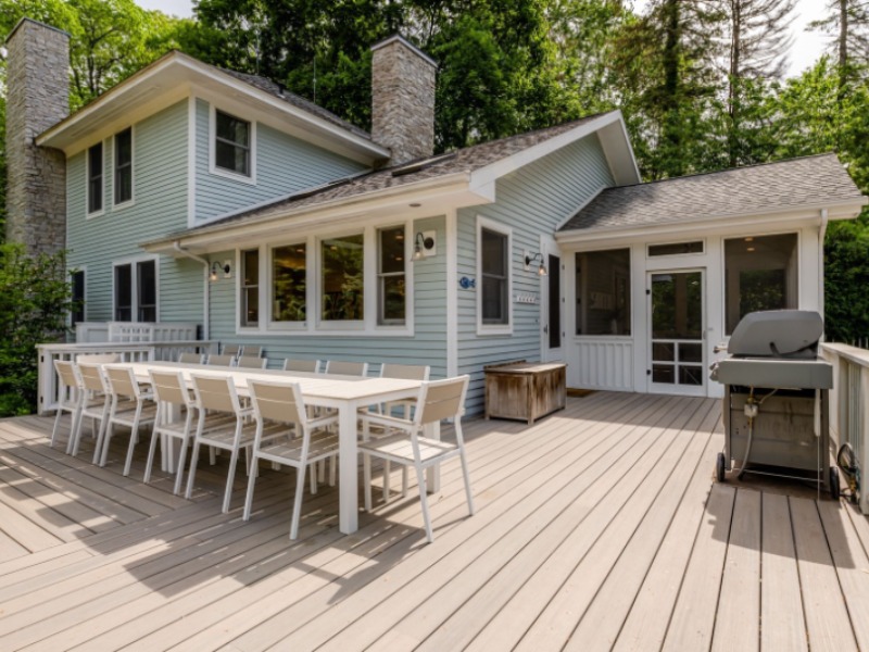 An expansive deck with a large dining table and grill at Fremont Shores vacation rental in Union Pier, MI.