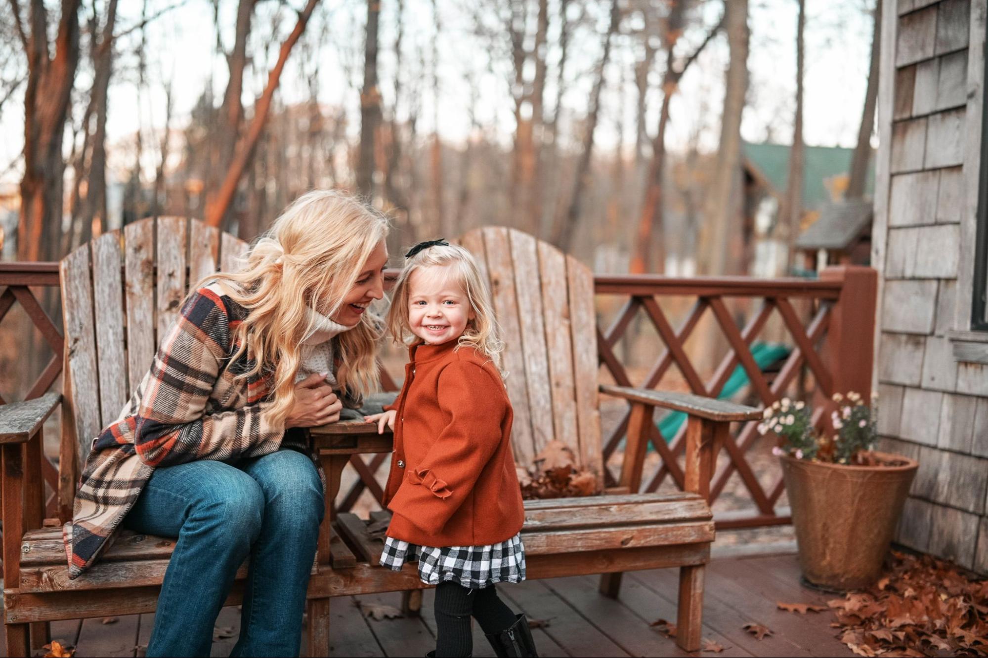Lake Michigan Getaways: A young mother and her daughter share a gleeful autumn moment on the porch of their vacation rental near Lake Michigan.